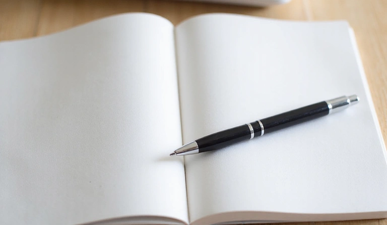Ein aufgeschlagenes Notizbuch mit einem Stift, symbolisiert Klarheit und Information.